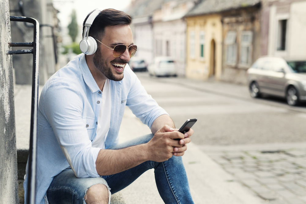 Young-man-watching-a-video-on-his-phone-in-an-urban-setting