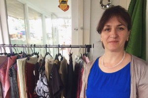 woman pictured in front of clothes